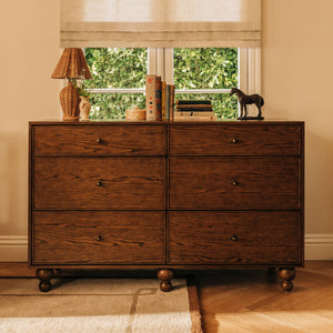 Front view of Astre 6-Drawer Wide Assembled Dresser in Toffee showcasing six drawers and rounded feet in a warm room