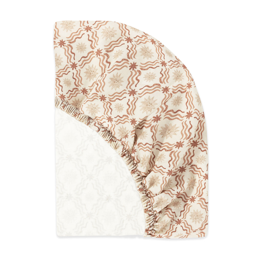 Folded view of All-Stages bassinet sheet showcasing the Autumn Star pattern on a white background