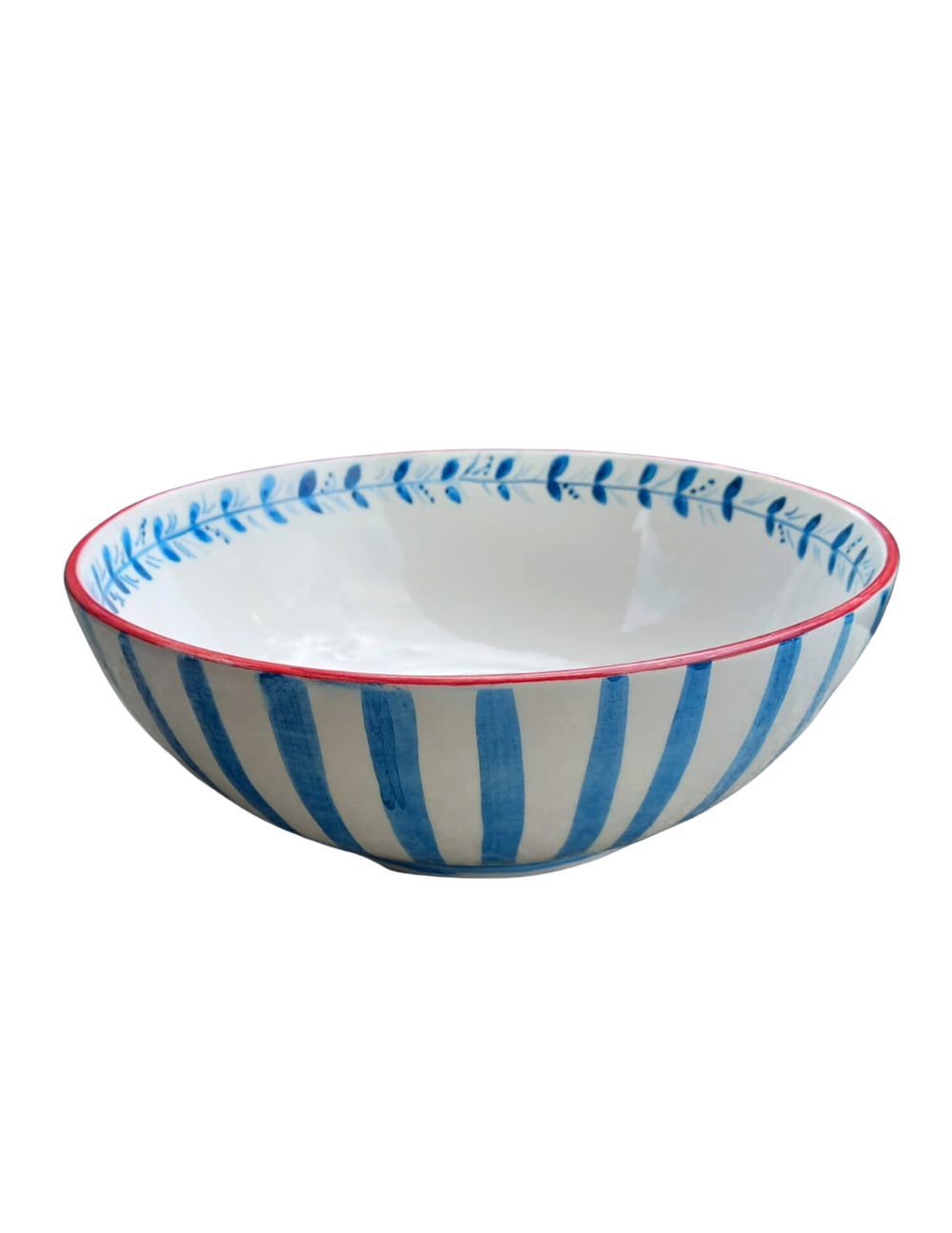 Three-quarter view of ceramic pasta/salad bowl with hand-painted blue stripes, leaf border and red rim on white