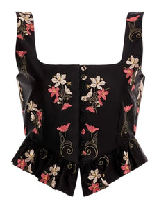 Front view of Eslabón Noche Cropped Top showcasing hand-embroidered floral placement print, button placket, and peplum hem