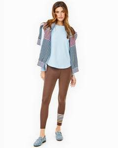 Model is wearing the Everyday Leggings in Chocolate and the Palmetto Long Sleeve in Baby Blue with the Varsity Quarter Zip in Navy/ Cherry Stripe around her shoulders