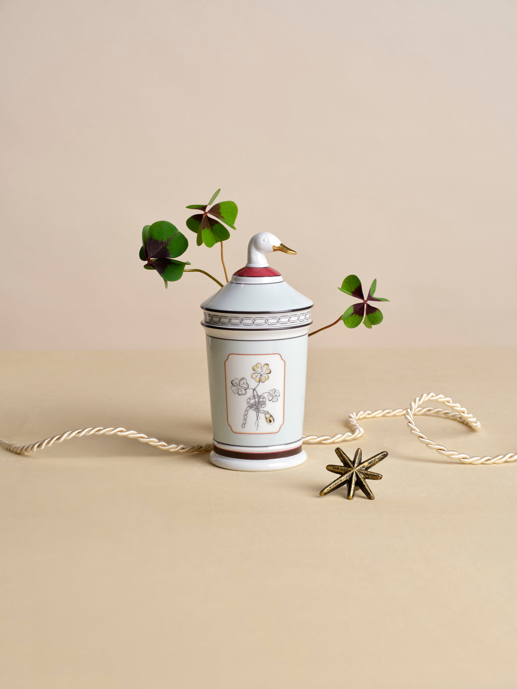 Fortunae Jar with Goose Lid styled with a four-leaf clover stem