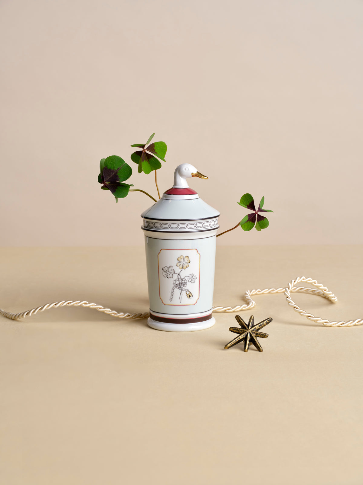 Fortunae Jar with Goose Lid styled with a four-leaf clover stem