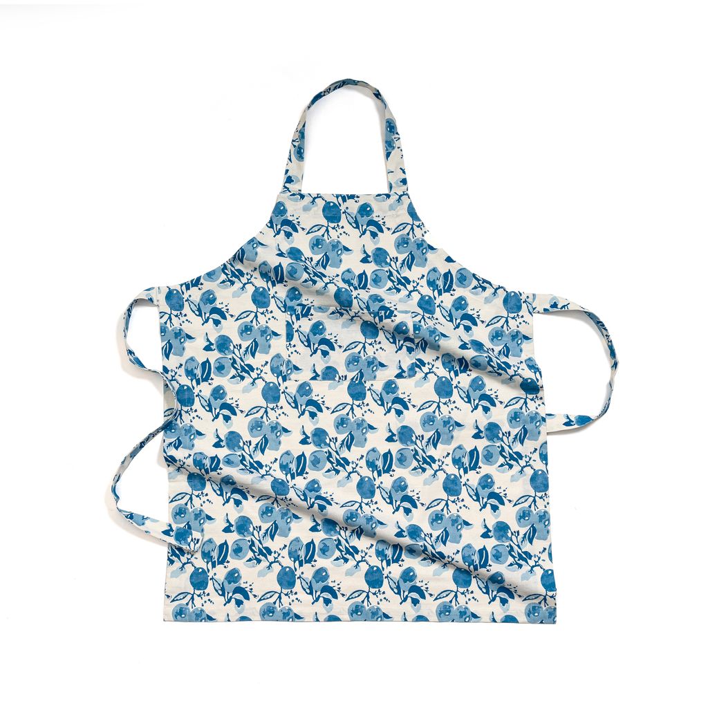 Front view of Citron Apron in Bleu showcasing its blue lemon and lemon blossom print with a white background