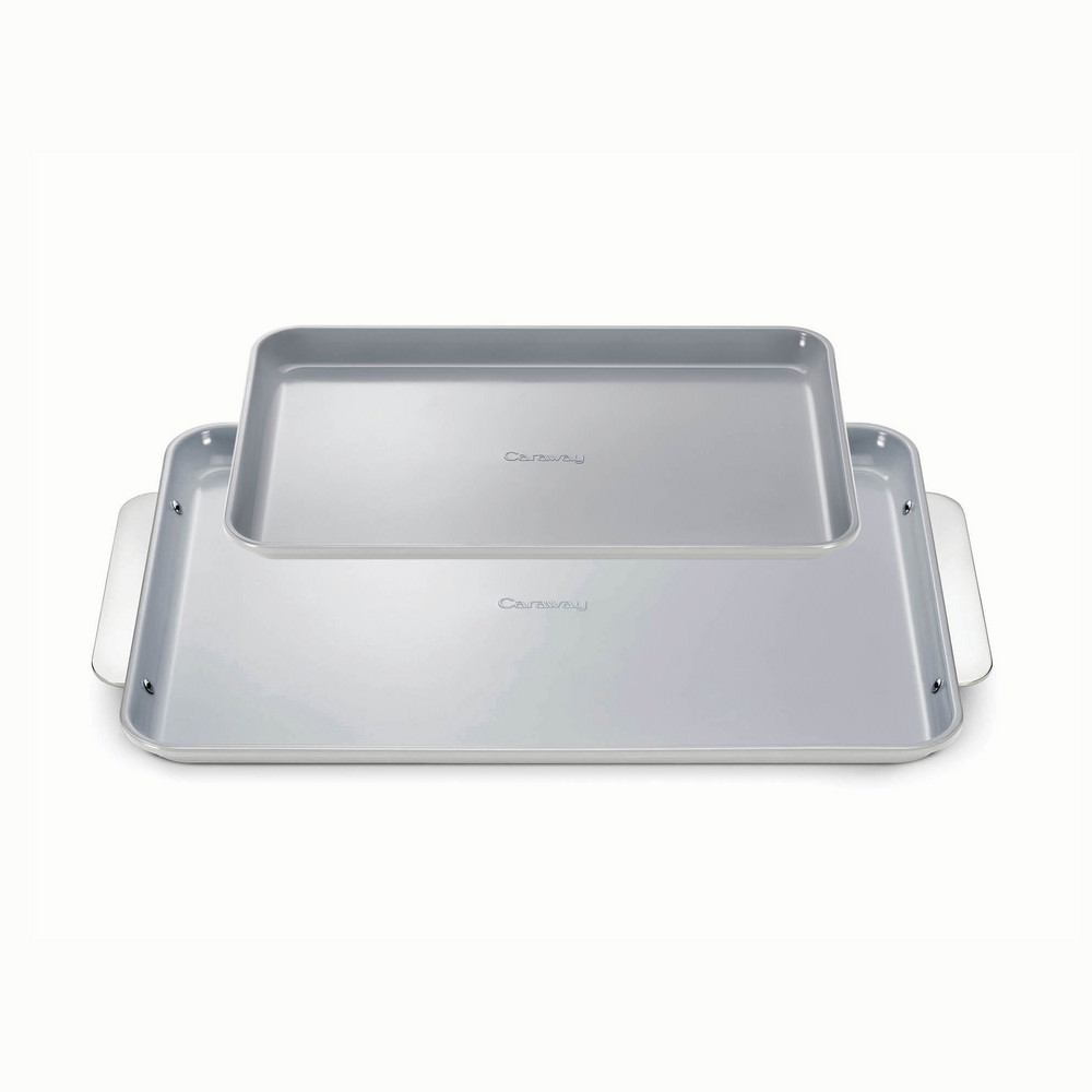 Top-down view of Baking Sheet Duo: two stacked gray baking sheets, one large rimmed pan with side handles on white background