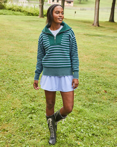 Model is wearing the Griffin Quarter Zip in Ivy/ Violet Stripe over the Fairmount Long Sleeve in Super White/ Violet Stripe with the Flounce Skort in Violet