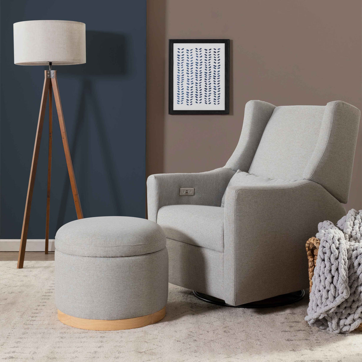 Front view of Naka Storage Ottoman in Performance Grey Eco-Weave showcasing its light wood base beside a nursery rocker