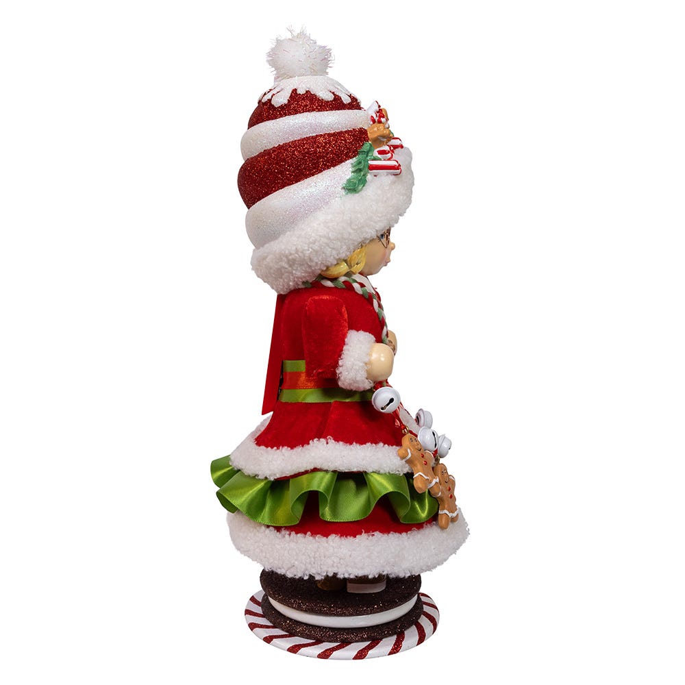 Profile of Mrs Claus Gingerbread Nutcracker in red velvet coat, green skirt, tall red-and-white glitter hat on white