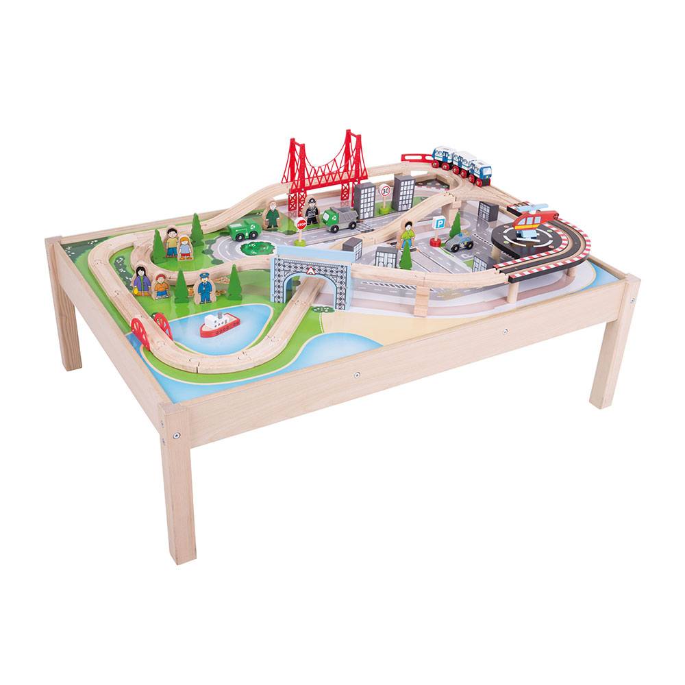 Three-quarter view of wooden City Train Table showcasing assembled 59-piece track set with raised ramps, red suspension bridge, metro-style train, boat, vehicles, and figures on a painted city play surface
