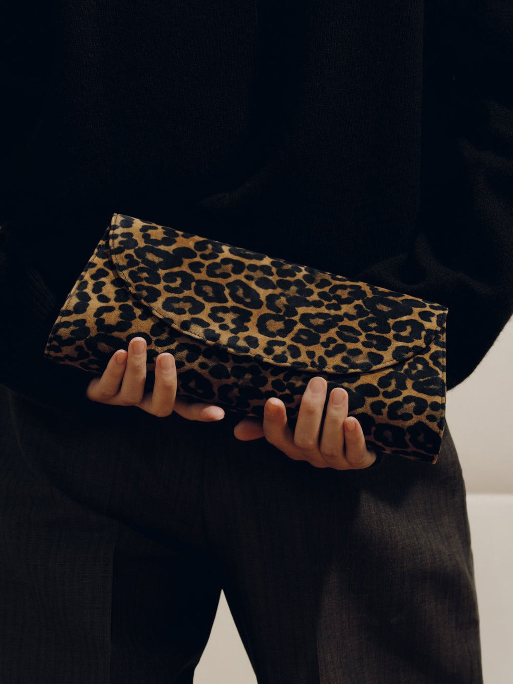 Front view of The Opera Clutch in Leopard Suede showcasing its leopard pattern with a dark background