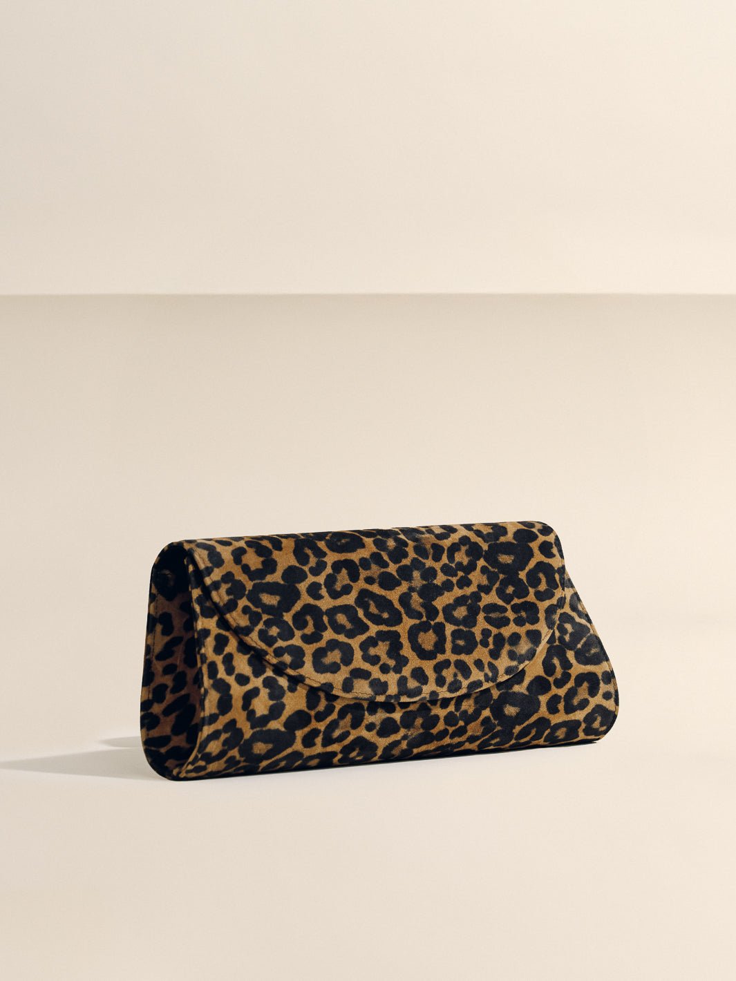 Angled front view of The Opera Clutch in Leopard Suede showcasing leopard pattern on a neutral background