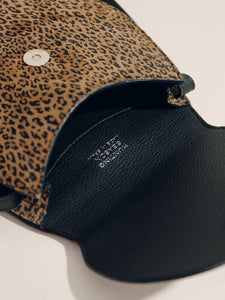 Close up of The Small Saddle Bag in Animal Print Suede showing its black fully lined interior and leopard print suede exterior