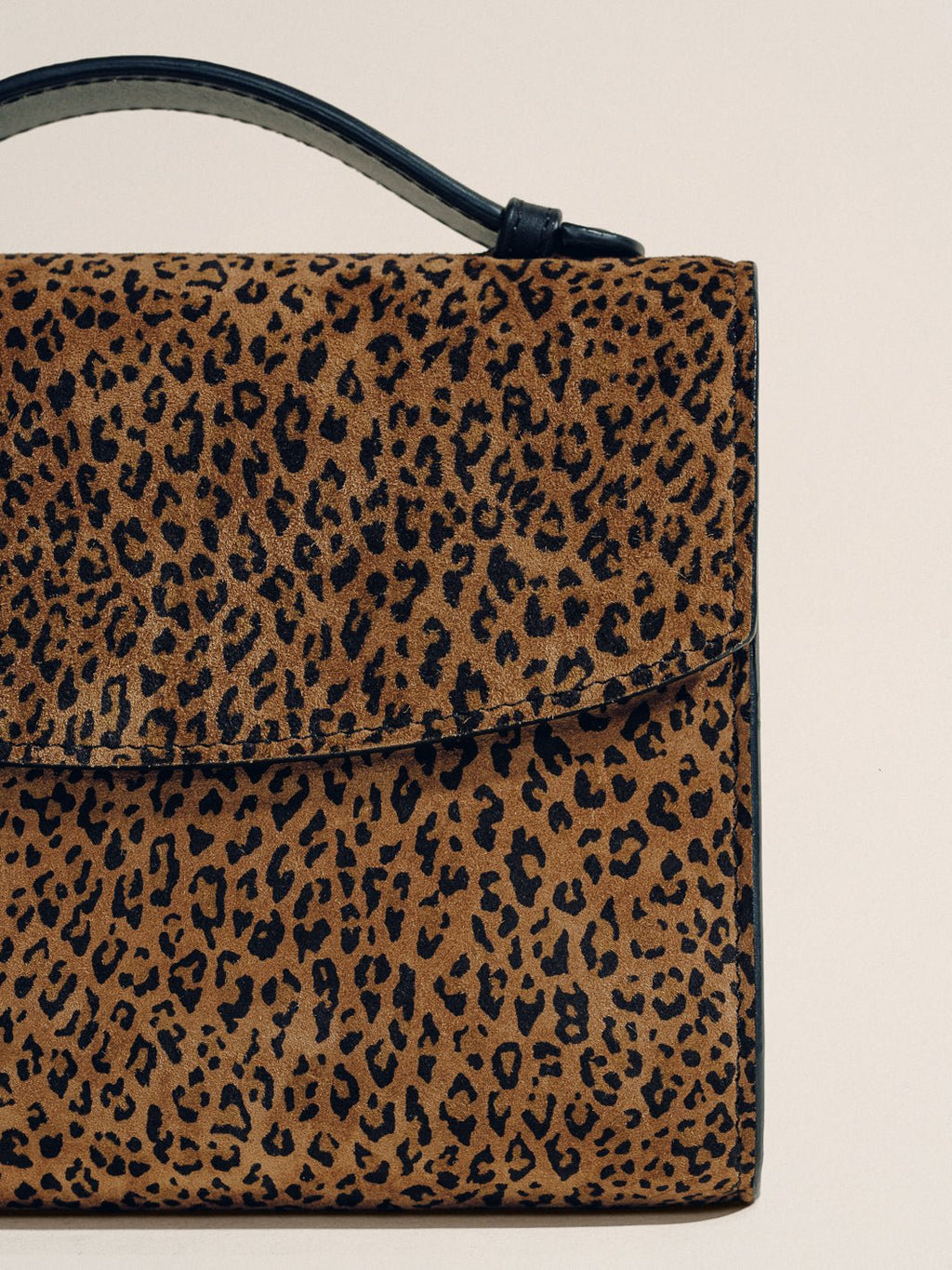 Front view of The Top Handle Clutch in Animal Print Nappa showcasing its top handle and animal print with a neutral background