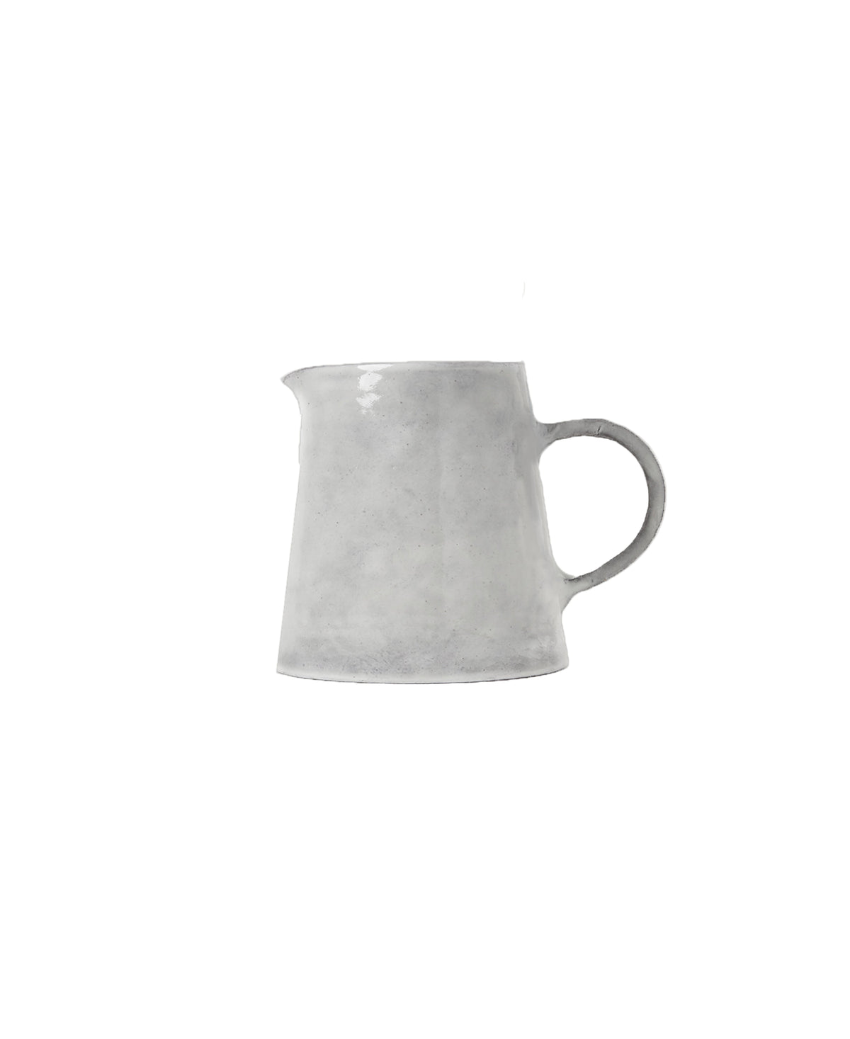 Front view of Assisi creamer showcasing tapered ceramic silhouette, short pouring spout and round handle on white background