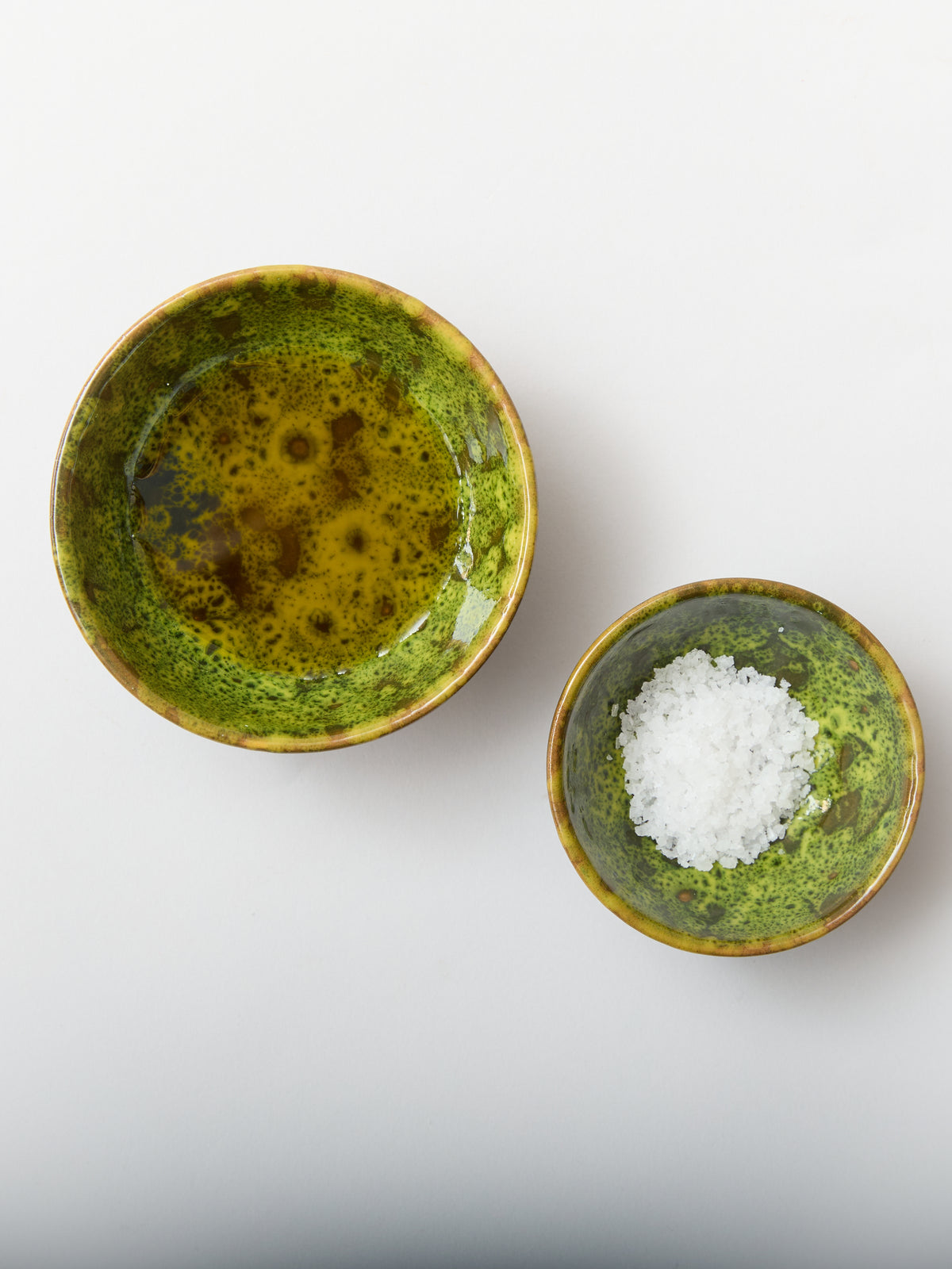 Top view of Moss Terracotta Oil & Salt Dish Set showcasing its moss-inspired glaze pattern with oil and salt on a white background