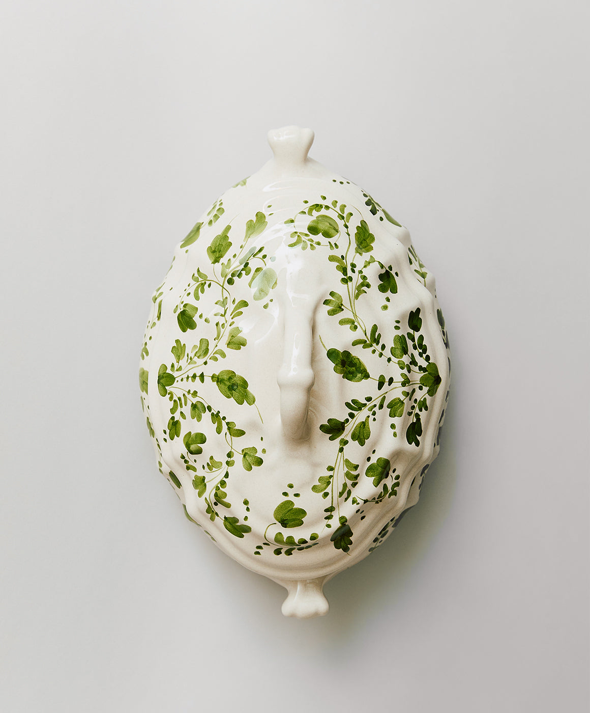 Top-down view of Flora tureen with lid showing hand-painted green floral motif on white terracotta on a light gray background