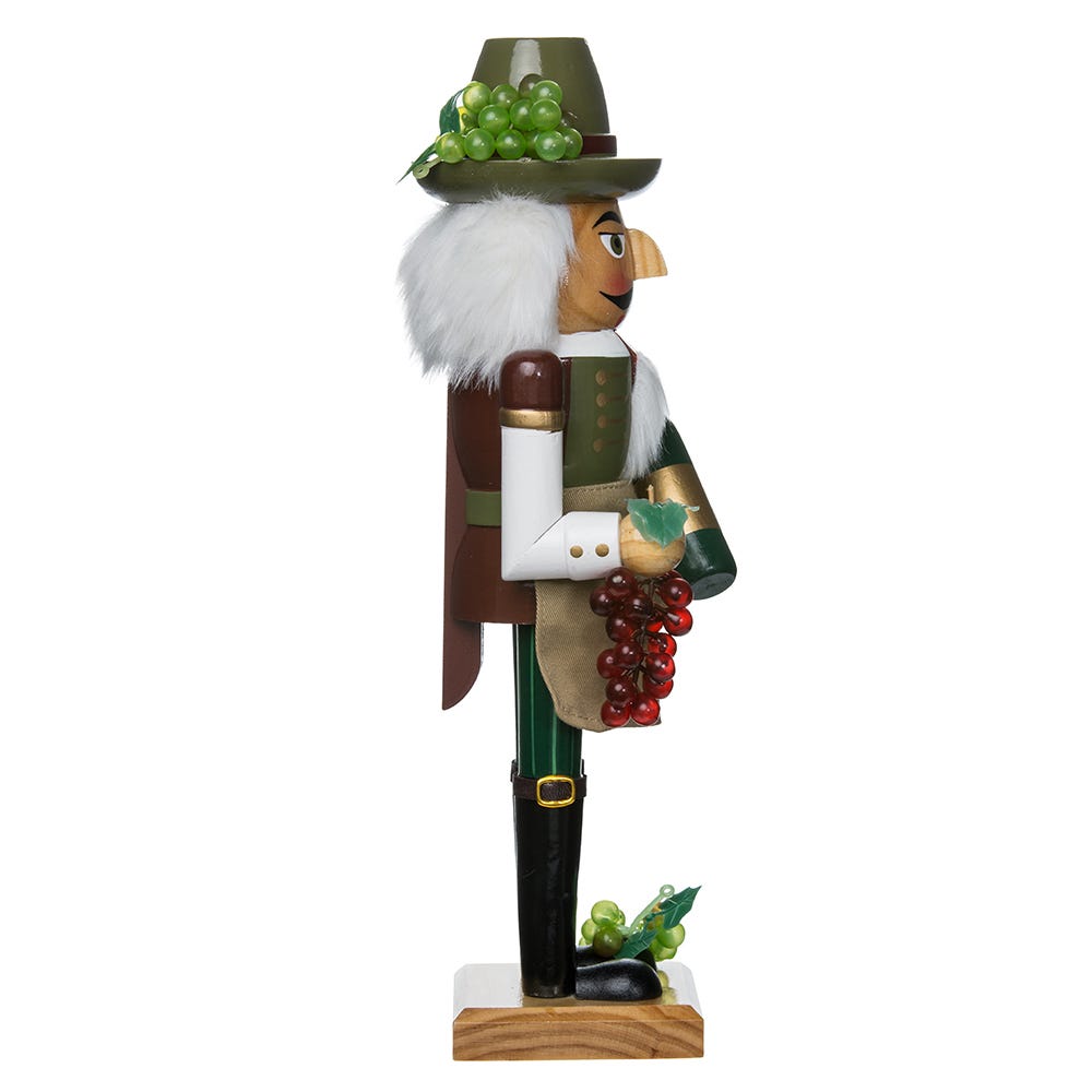 Right-side view of Wooden Wine Grower nutcracker showcasing grape clusters, a wine bottle, white faux hair, and a wooden base on white background