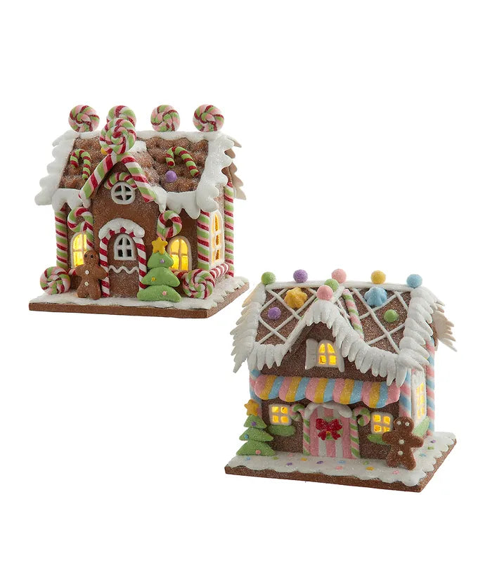 Front view of lollipop house and bubble gum factory ornaments with candy details and glowing windows on white background