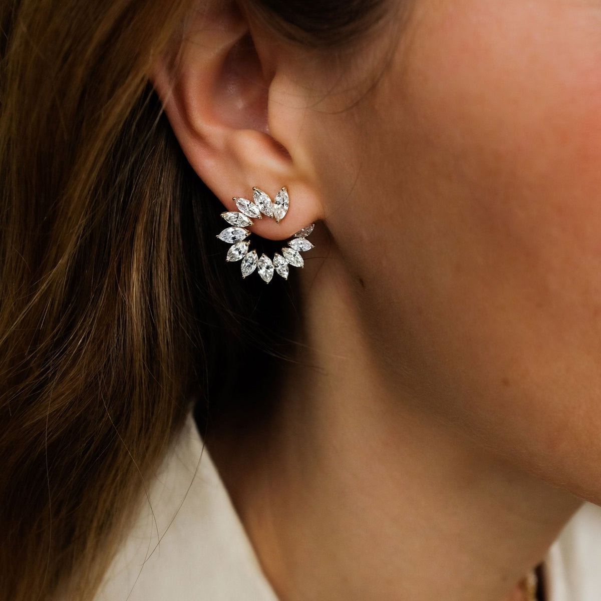 Close-up side view of Narcissa Diamond Crescent Earrings showcasing marquise-cut diamonds in a crescent C-shape on a model’s ear