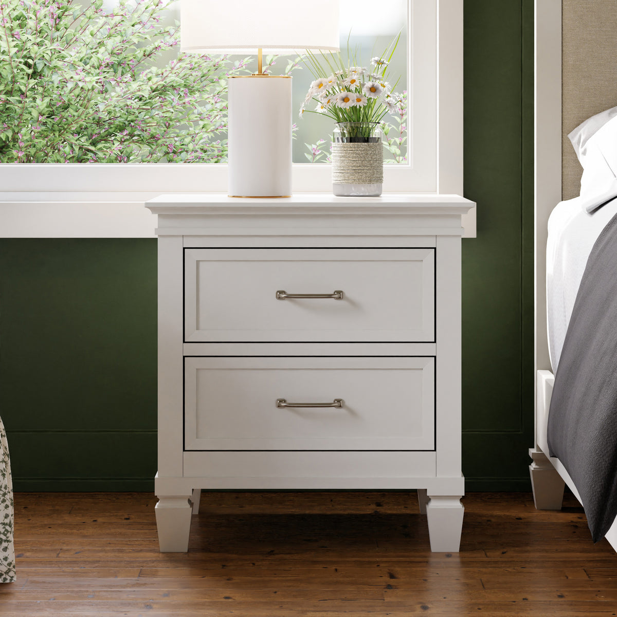 Front view of Darlington Assembled Nightstand in Warm White showcasing two drawers and tapered legs in a bedroom