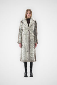 Grey and cream snow leopard faux fur coat with notch lapel and full-length, relaxed fit, worn over black knee-high boots, front view