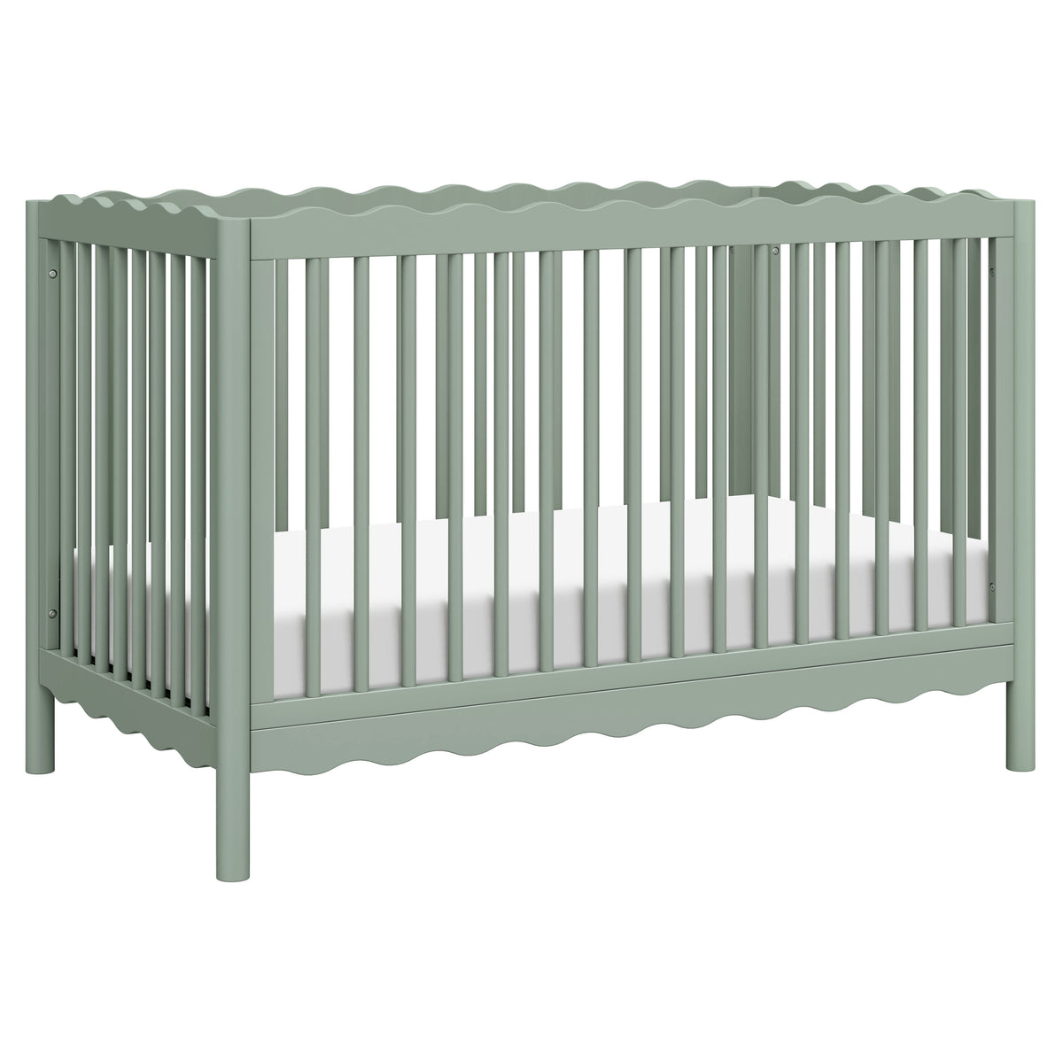 Three-quarter view of Swell 4-in-1 convertible crib showing scalloped rails, vertical slats, and light sage finish on white