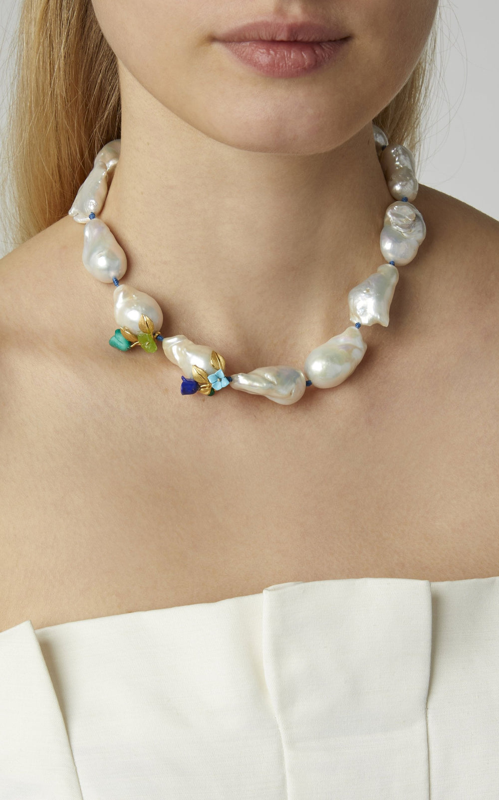 Close-up of Power Pearl Necklace on model showcasing large baroque pearls, mint and lapis flower accents, and blue silk cord