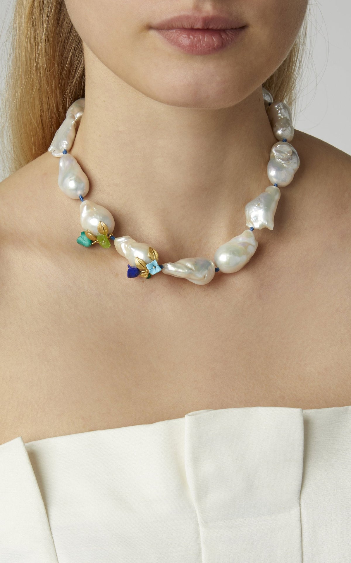 Close-up of Power Pearl Necklace on model showcasing large baroque pearls, mint and lapis flower accents, and blue silk cord