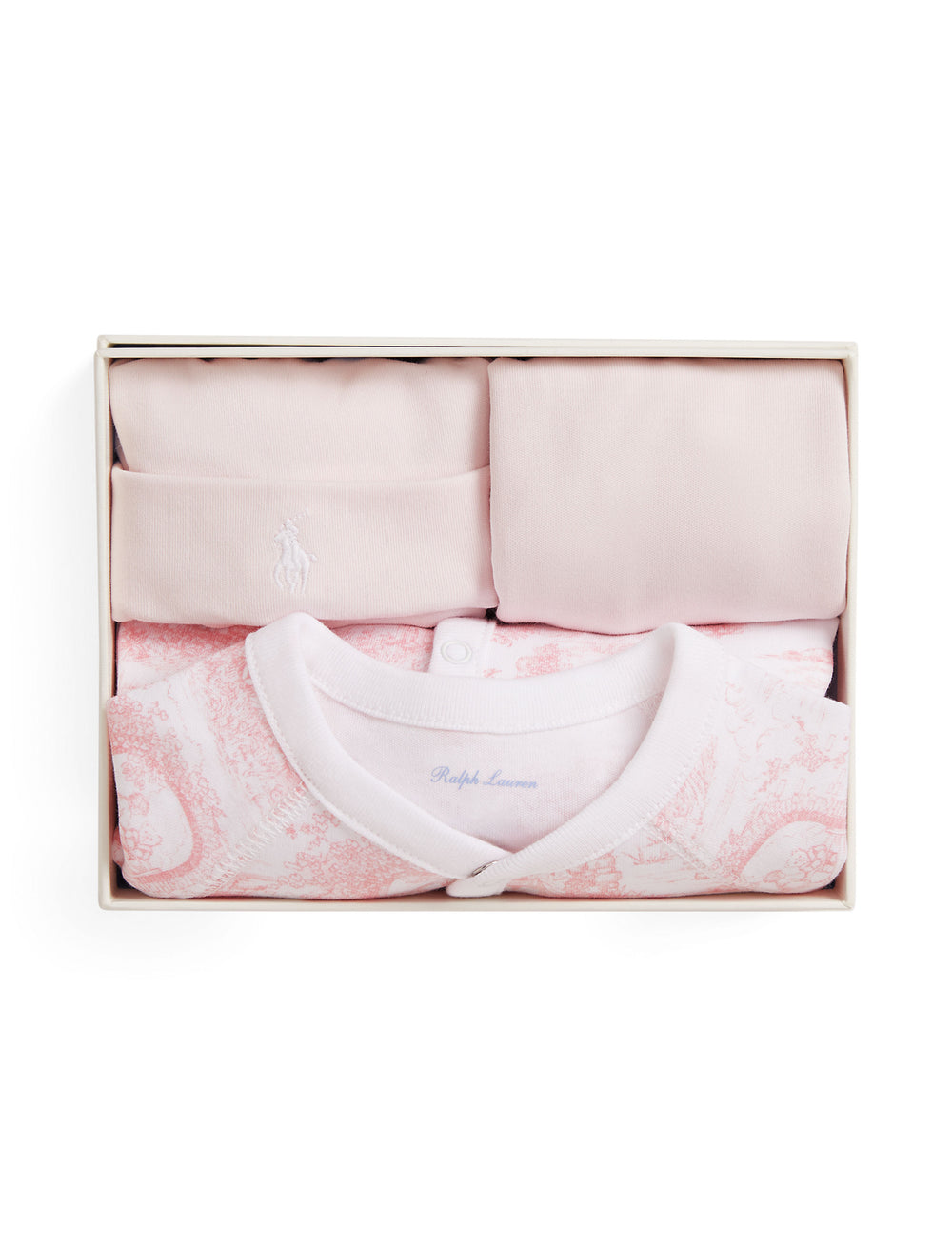 Top-down view of a 3-piece pink toile baby box set with folded long-sleeve bodysuit, hat, and blanket in a white gift box