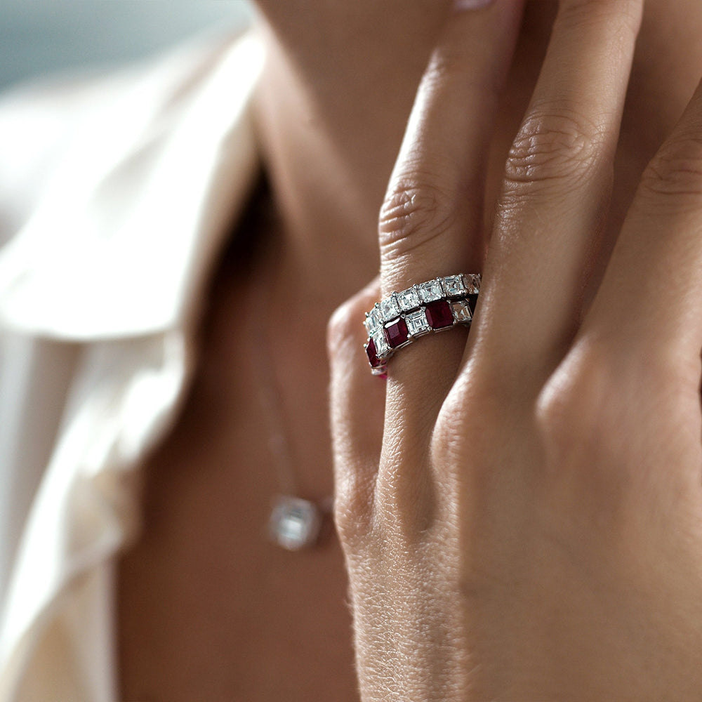 Close-up of Serenata Ruby Band showcasing alternating carré-cut rubies and diamonds set in 18K white gold on a model’s hand