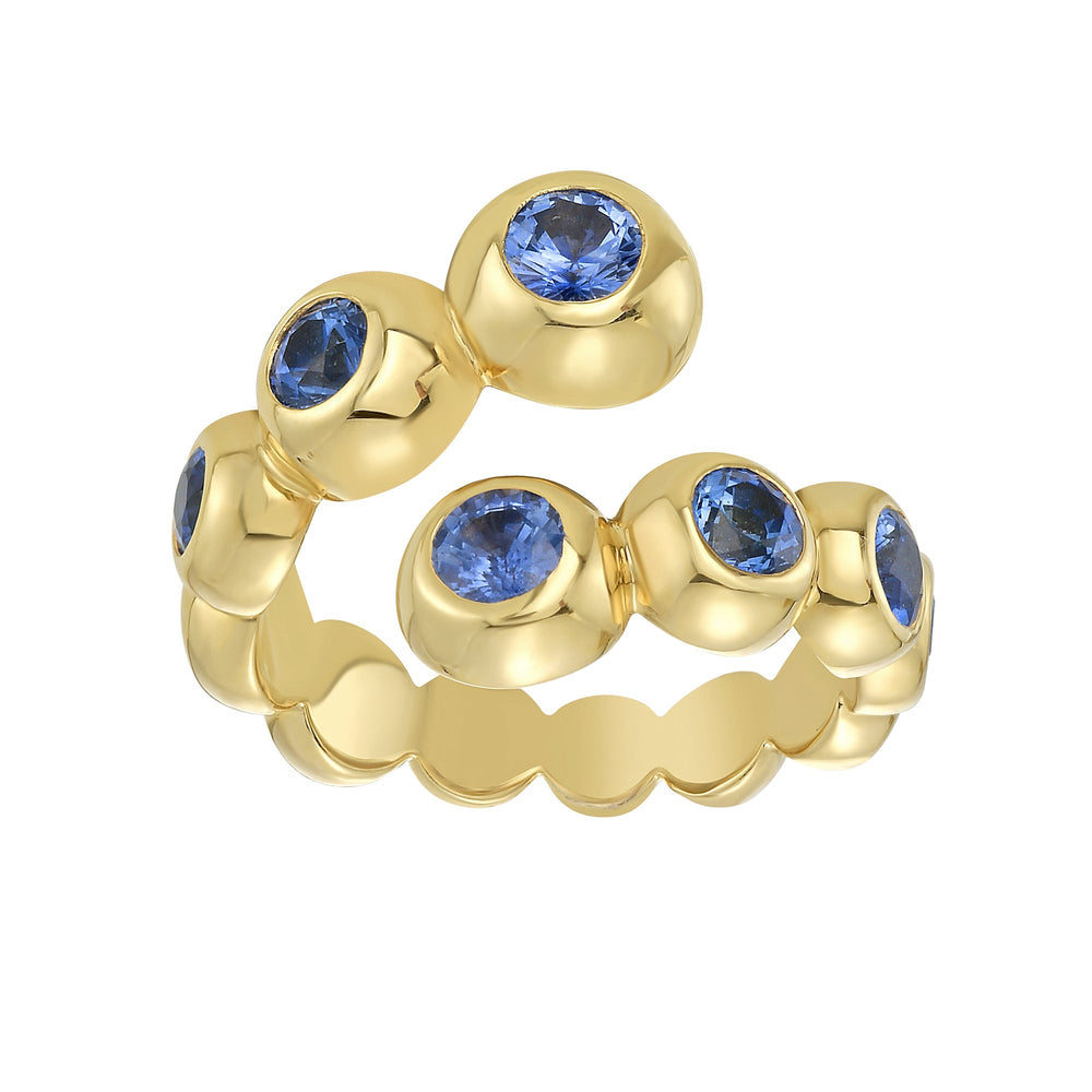 Angled view of Marguerite wrap ring showcasing bezel-set blue sapphires in 18K yellow gold on white background