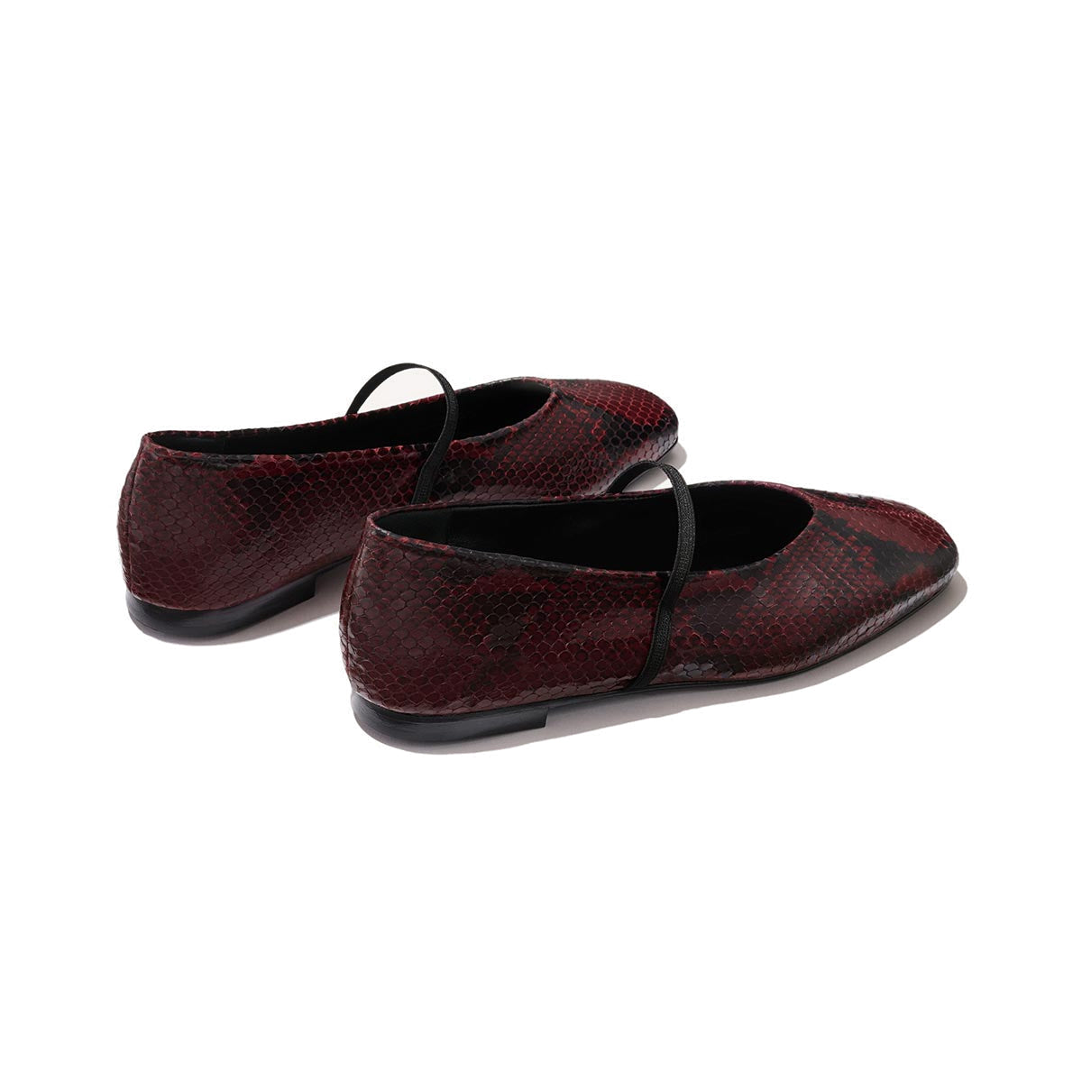 The Phoebe by margaux-development: burgundy python-embossed Mary Jane flats with black straps, sacchetto construction for superior comfort, shown from the back and side on a light background.