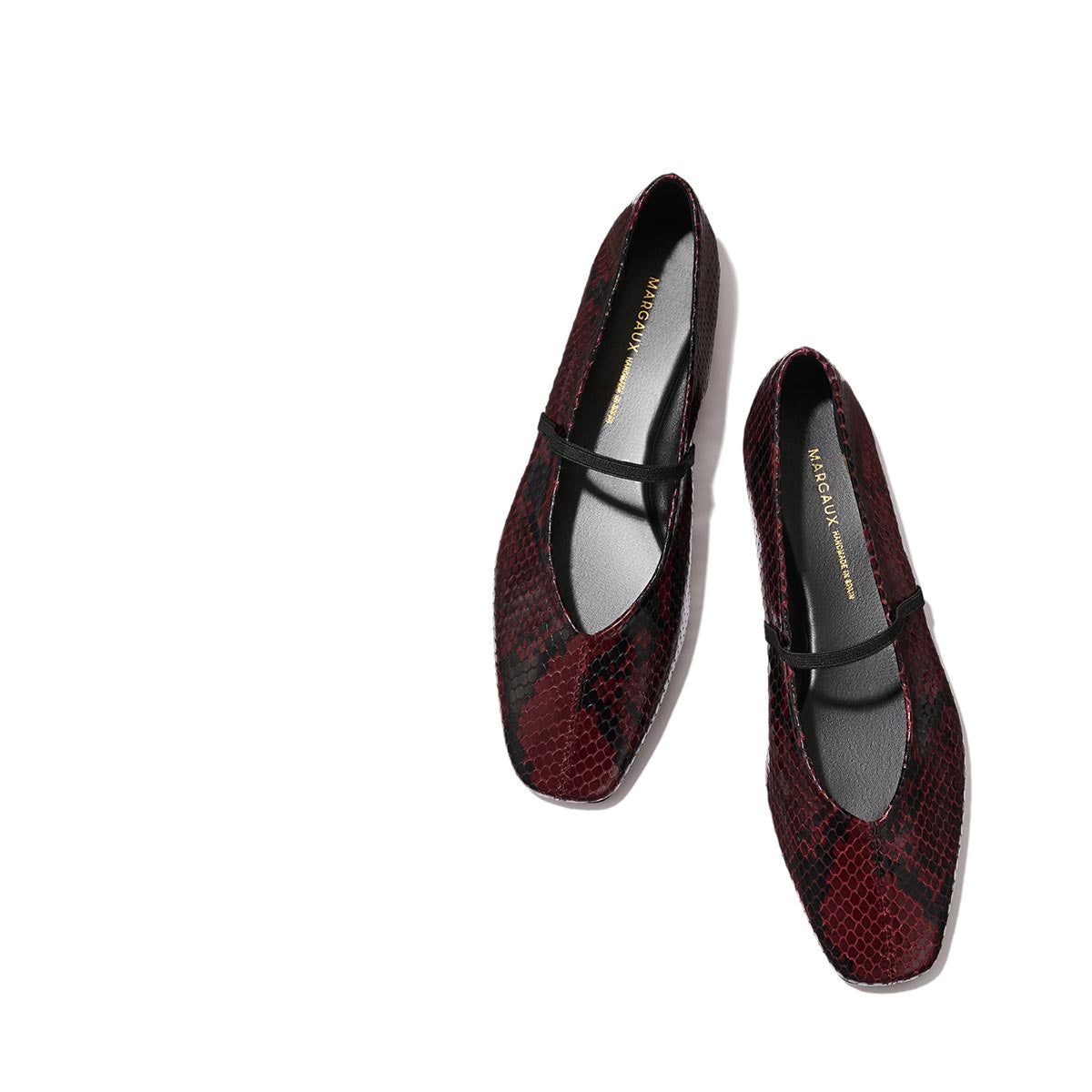 The Phoebe - Burgundy Python Embossed by margaux-development: burgundy and black snakeskin-patterned Mary Jane flats with a single black strap, sacchetto construction for plush comfort, shown on a light beige background.