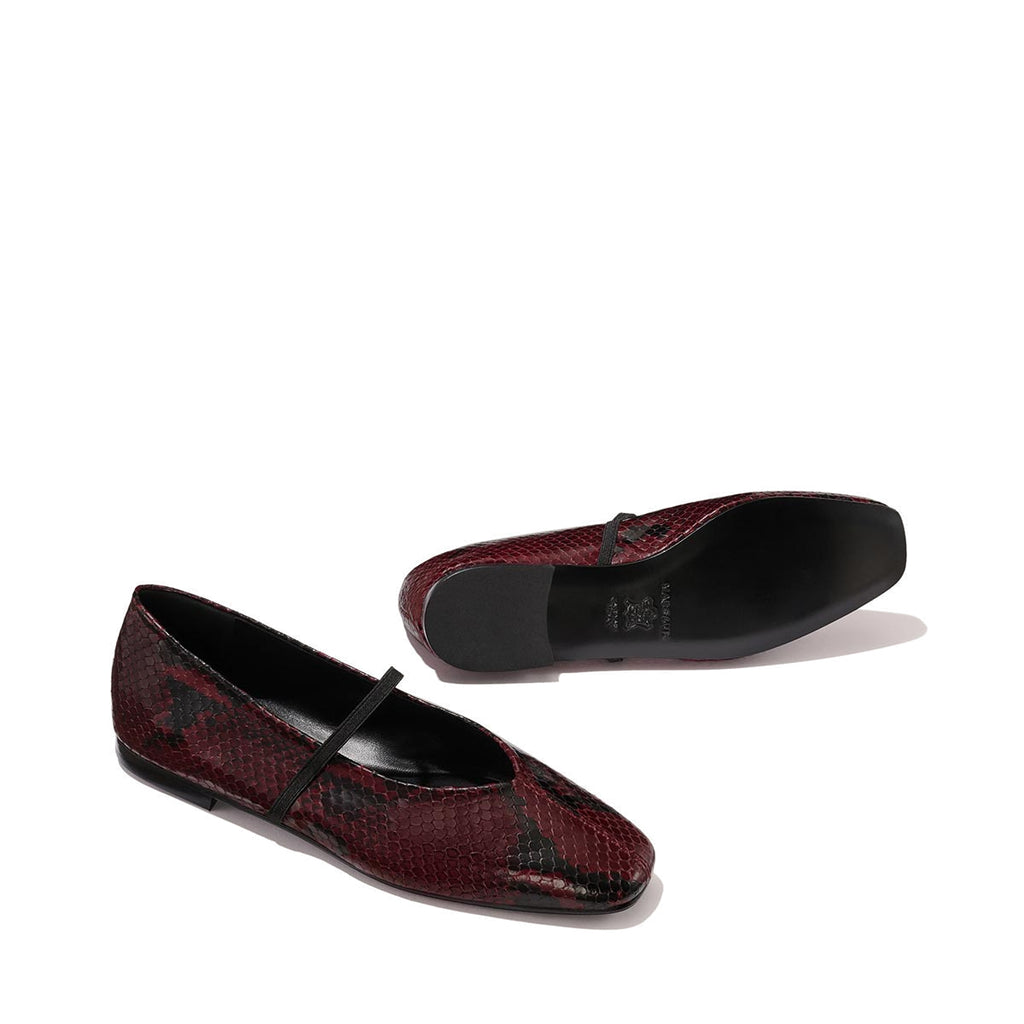 The Phoebe - Burgundy Python Embossed by margaux-development: ballet flats in burgundy python embossing with black soles and a slim black strap, crafted with sacchetto construction for exceptional softness, shown on a plain light background.