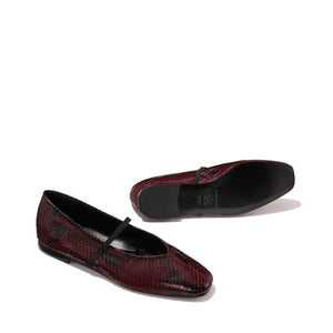 The Phoebe - Burgundy Python Embossed by margaux-development: ballet flats in burgundy python embossing with black soles and a slim black strap, crafted with sacchetto construction for exceptional softness, shown on a plain light background.