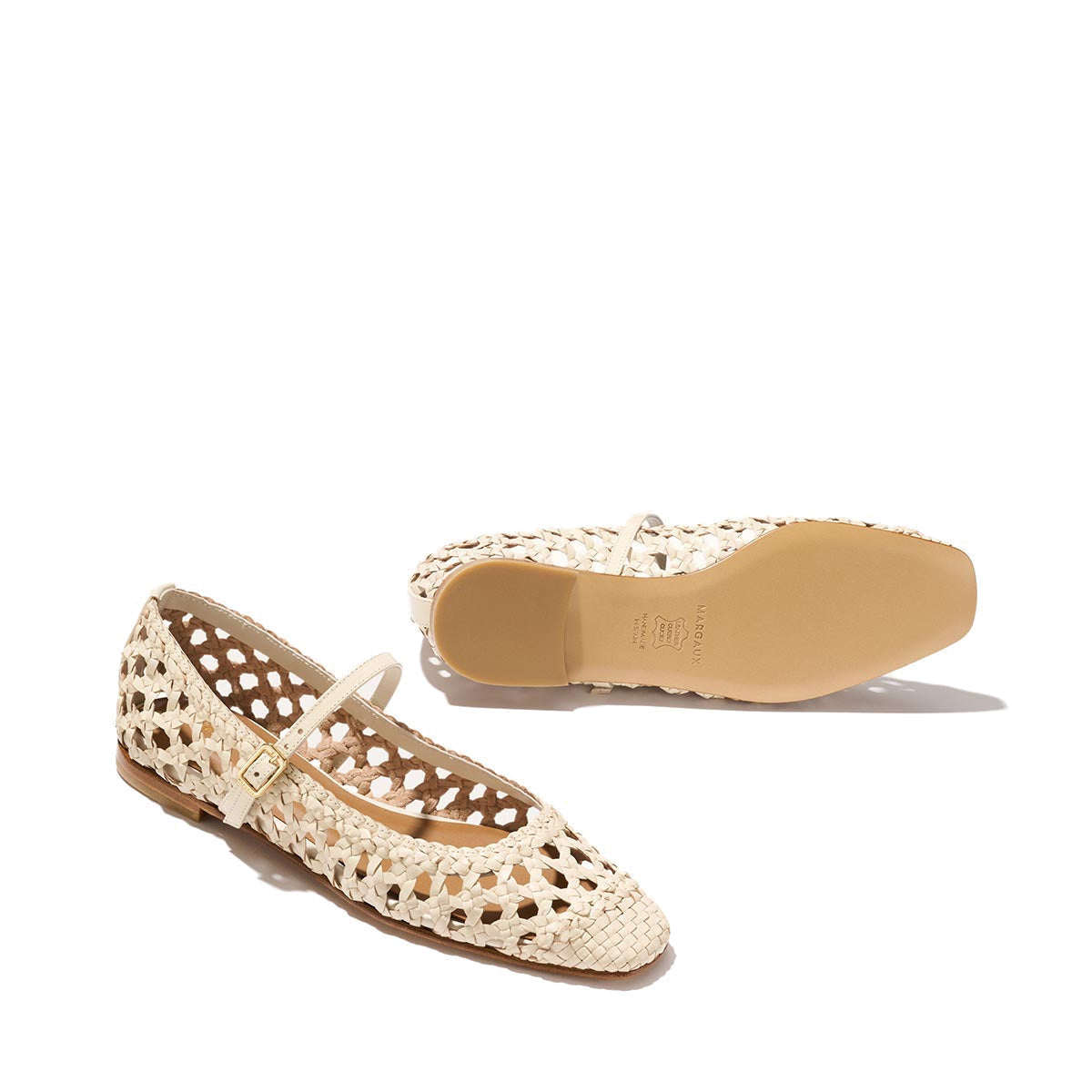 The Fonteyn Jane - Ecru Woven Leather flats by Margaux feature a handwoven cream finish and adjustable strap. One shoe is upright, showing the side and top, while the other reveals the sole against a plain, light background.