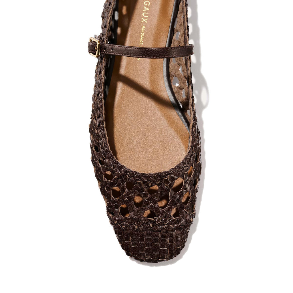 Top view of The Fonteyn Jane - Espresso Woven Leather flat by Margaux features a brown handwoven leather, closed rounded toe, and an adjustable strap with gold buckle, displayed on a light background.