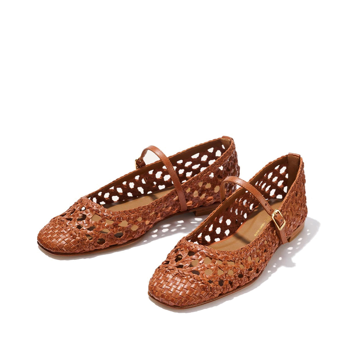 Margaux's The Fonteyn Jane - Saddle Woven Leather flats feature brown handwoven leather, perforated detailing, adjustable ankle straps, and gold buckles, shown on a light background.
