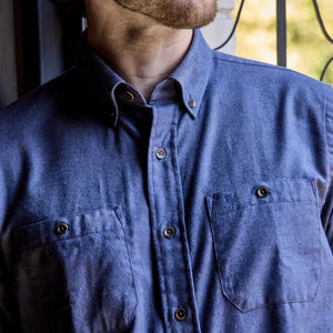 A person wears a Tom Beckbe Dixon Brushed Cotton Twill Shirt with two chest pockets, standing by a window.