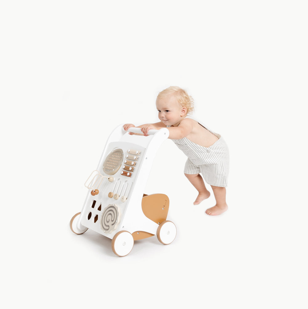 Three-quarter view of Activity Walker with play panel and bead maze, toddler pushing on white background