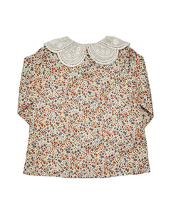 Floral blouse with lace collar on a white background