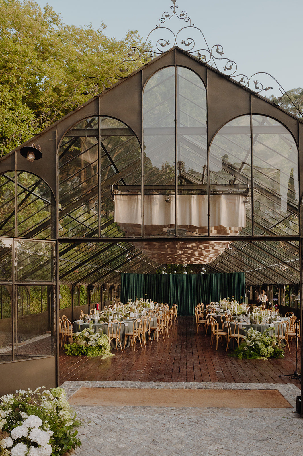 Wedding reception tables arranged inside a glass greenhouse in Sintra, Portugal