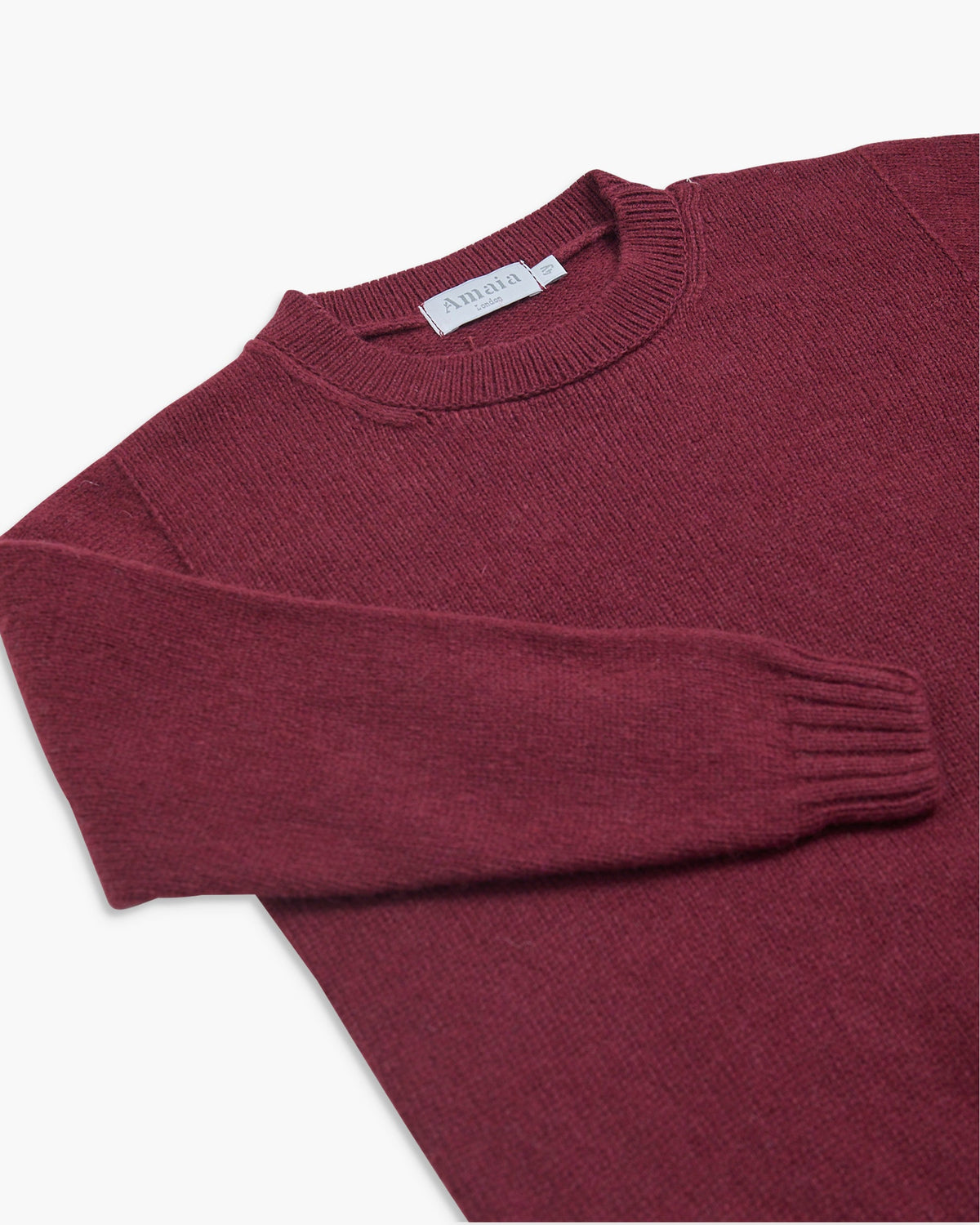 Maroon sweater with a brand label on a white background