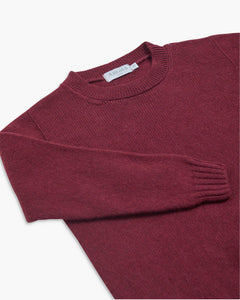Maroon sweater with a brand label on a white background