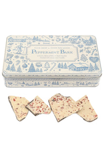 Angled view of Tuck Shop for Over The Moon peppermint bark with peppermint-topped chocolate pieces and keepsake tin
