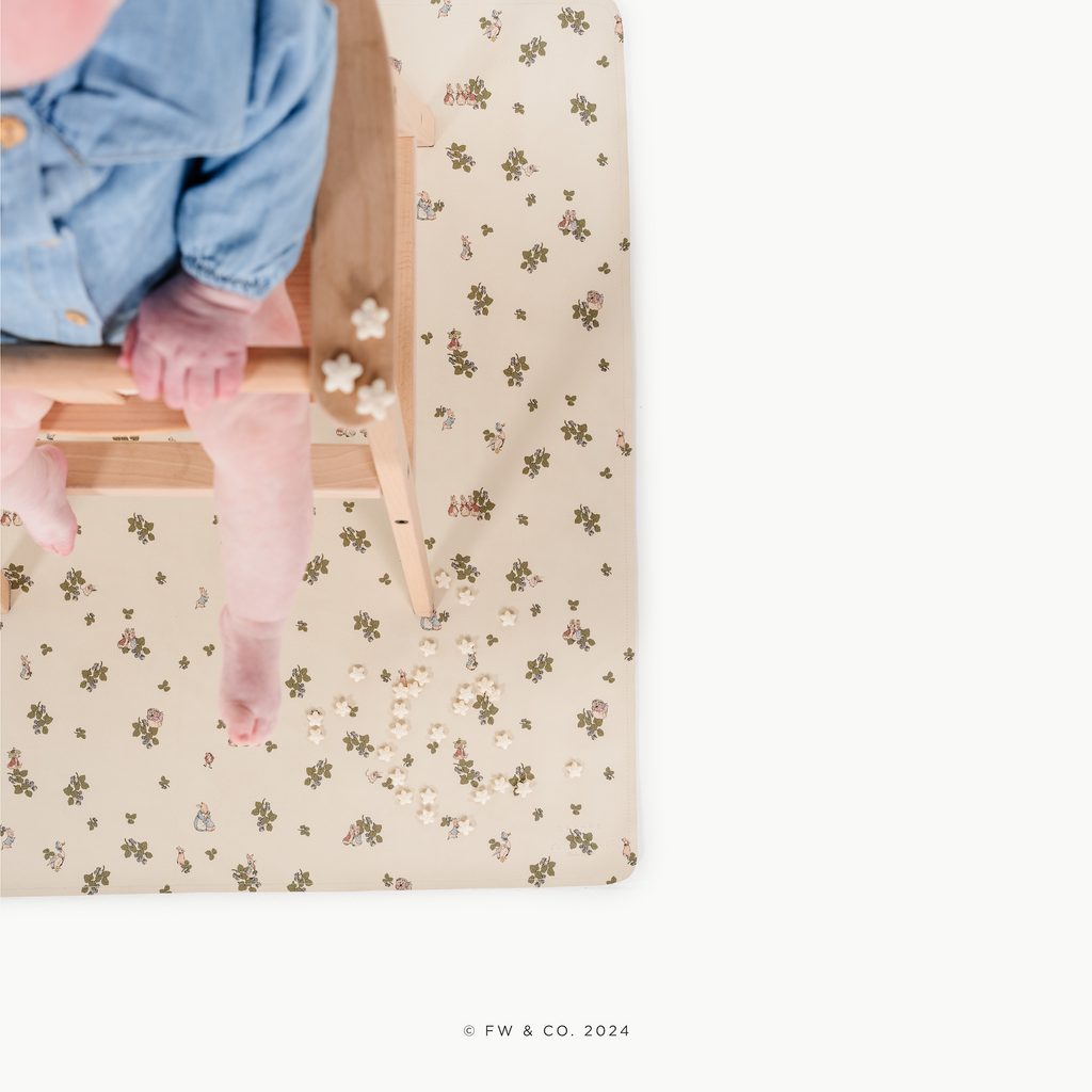 Peter Rabbitª@overhead of little girl in a high chair on a mat