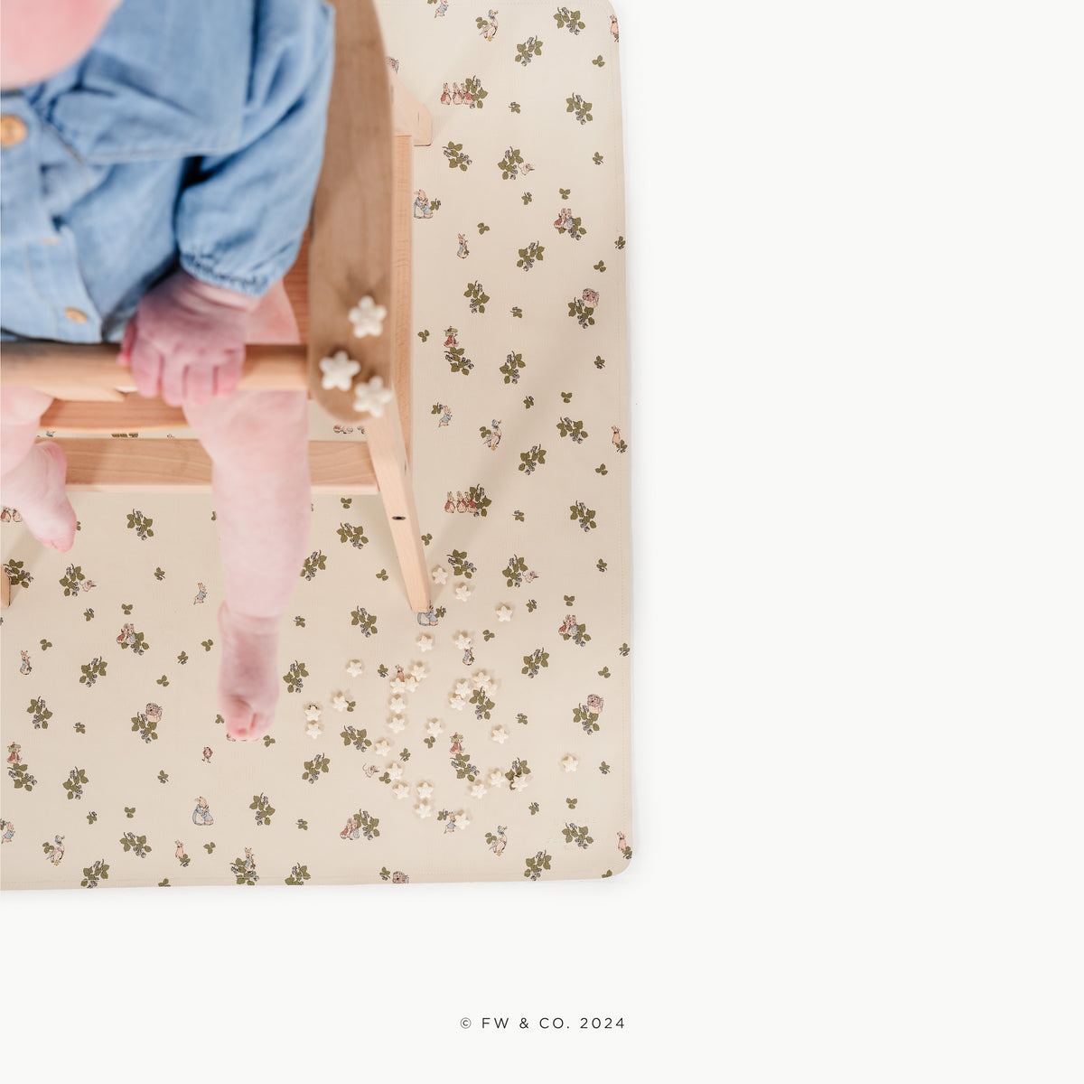 Peter Rabbitª@overhead of little girl in a high chair on a mat
