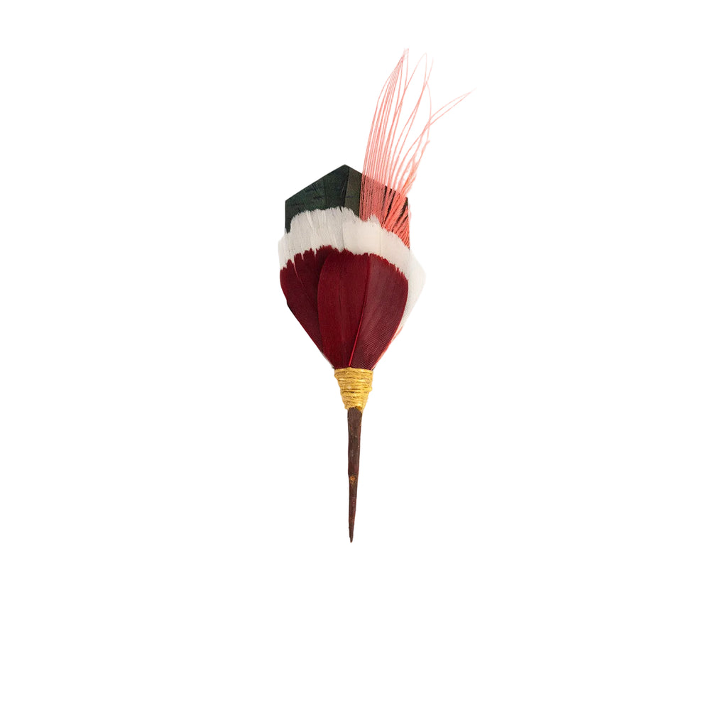 Front view of Praslin Pin showing layered burgundy and white feathers with coral accent and green iridescent base on white background