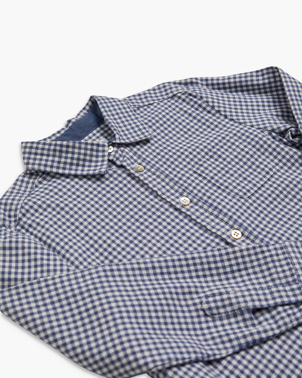 Folded blue and white checkered shirt on a white background