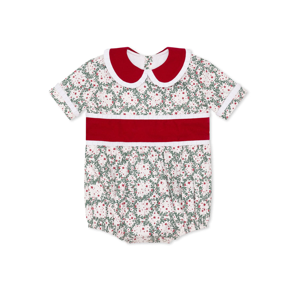 Grace Bubble in Regent Wreaths holiday print with red velvet sash and Peter Pan collar, finished with crisp white pleated trim for baby and toddler girls.